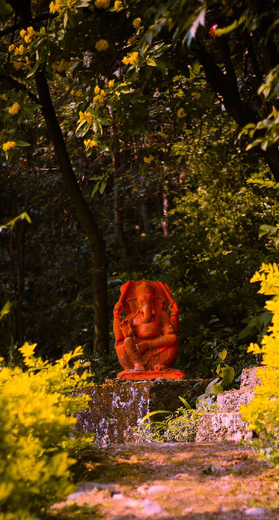 Red Ganesh statue in the campus garden surrounded by yellow flowers